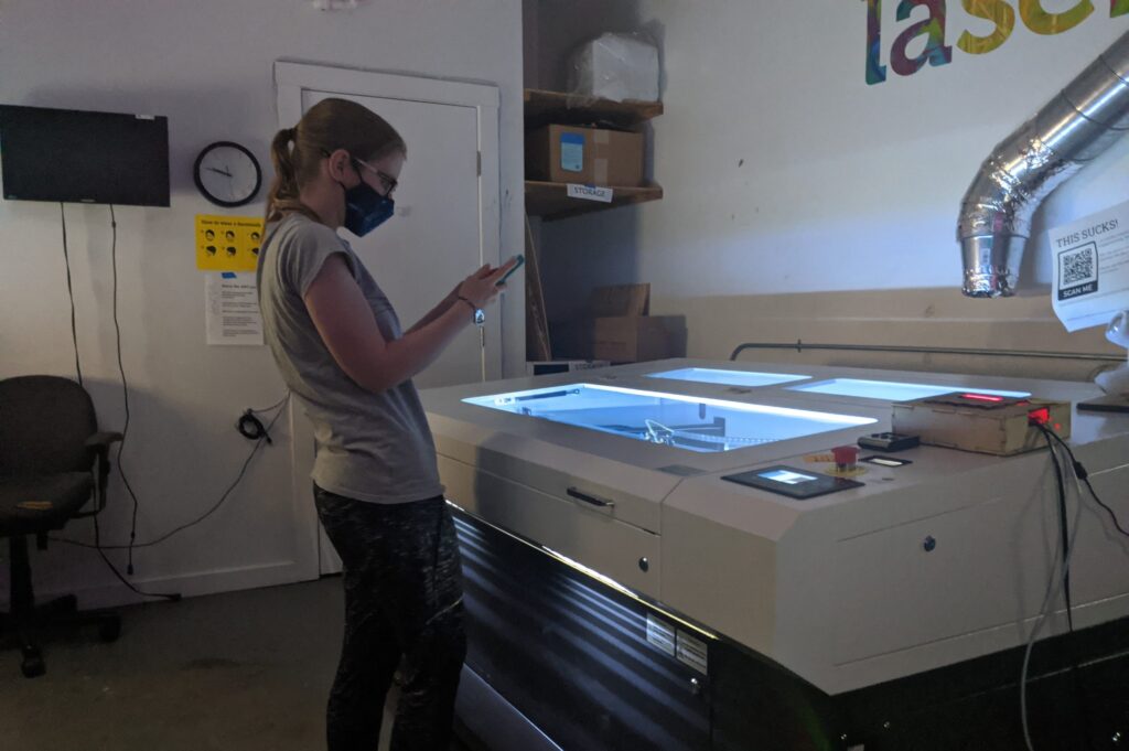Maker working on a project at the laser cutter