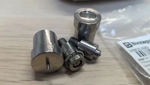 4 pieces of hardware on a wooden table.