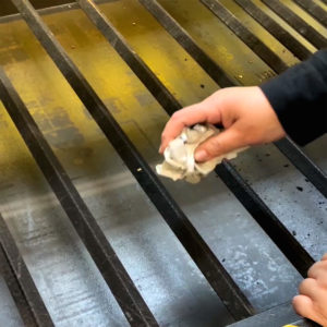 Image of yellow and silver laser bed and hands holding a scrubber