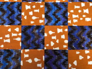 Blue and orange quilt block with ceramic motif.