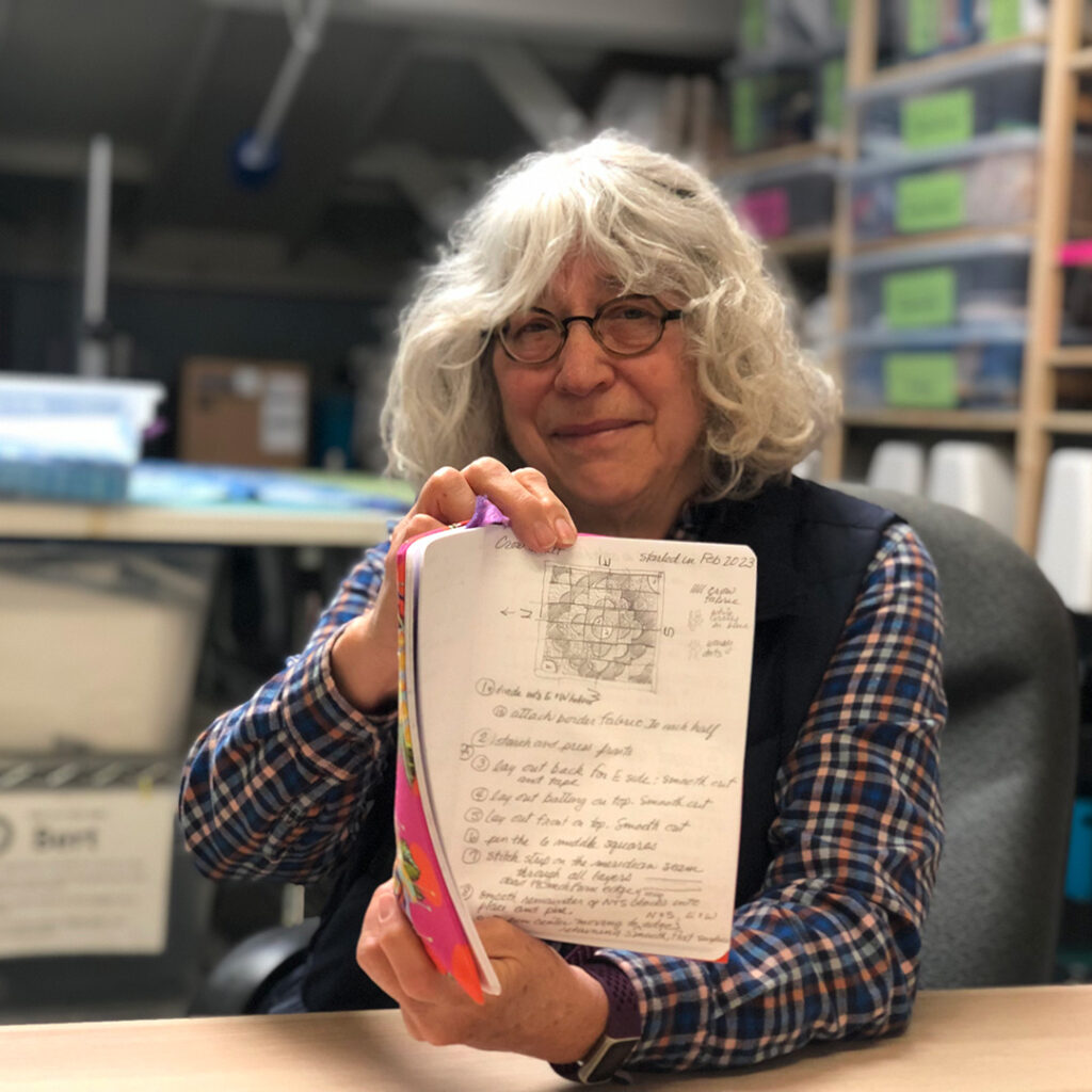 Terry holds up a preliminary sketch for her "Angry Birds" crow quilt.