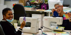 People smiling with sewing machines