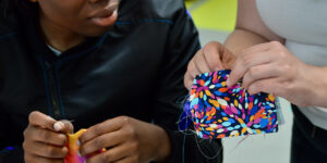 Student and teacher sewing
