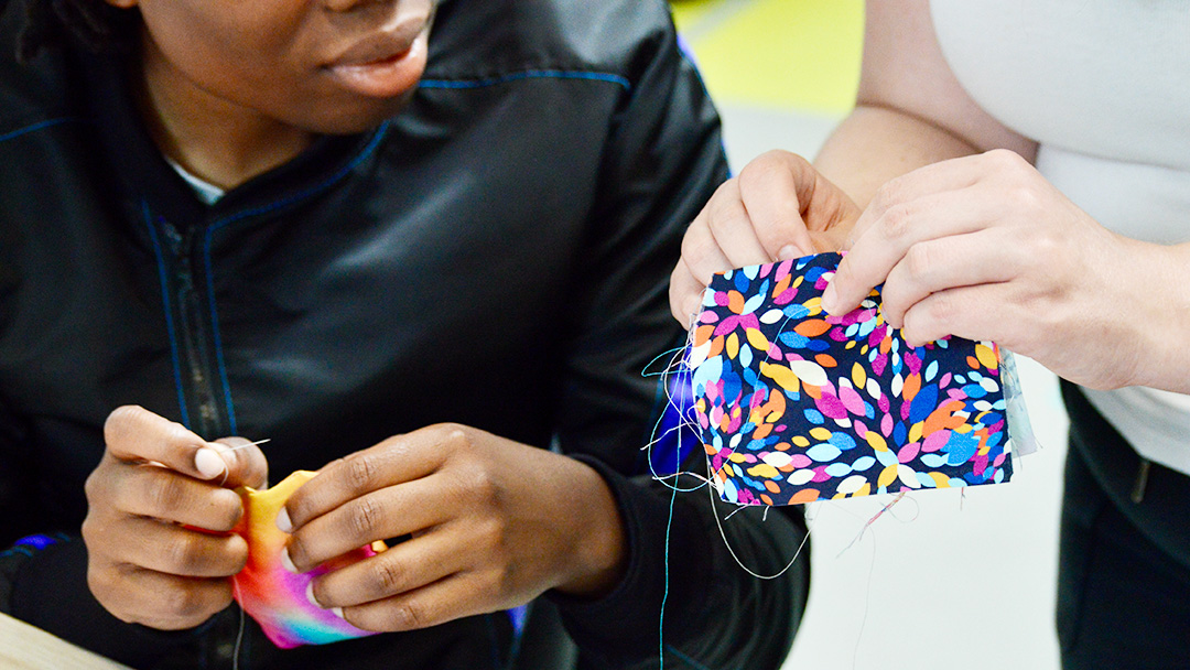 Teacher and student sewing