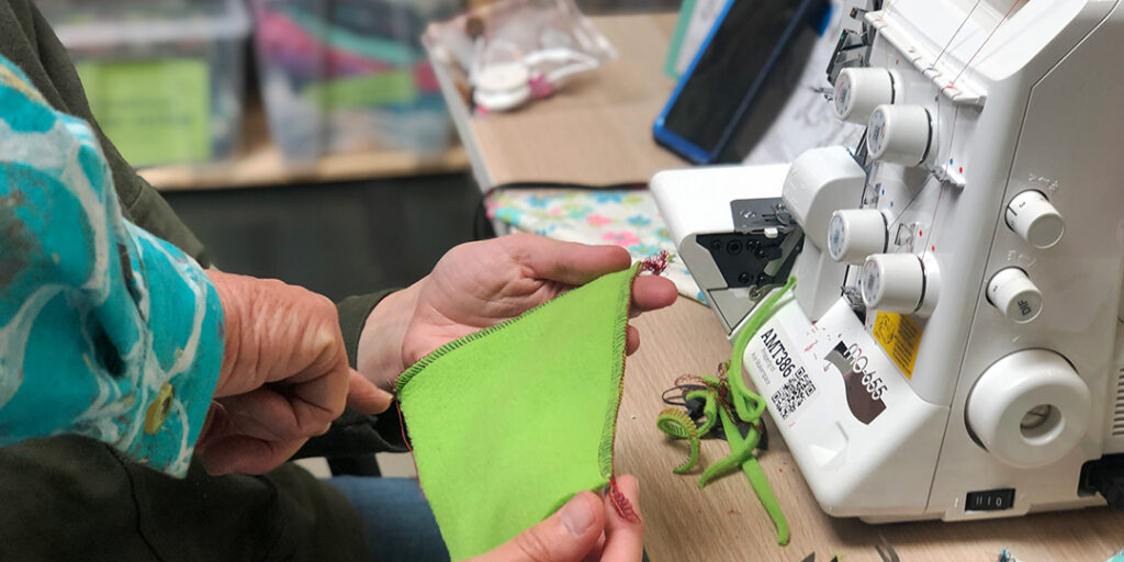 Teacher pointing at serged hem, serger