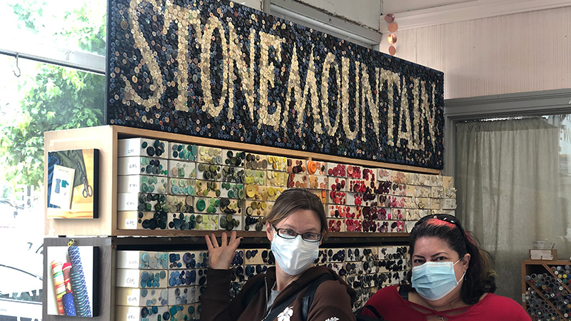 Two people posing with"Stonemountain" button mosaic.