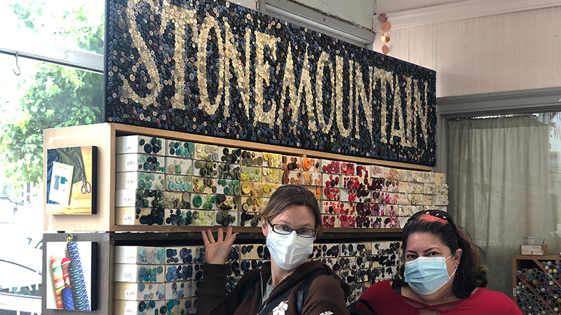 Two people posing with"Stonemountain" button mosaic.