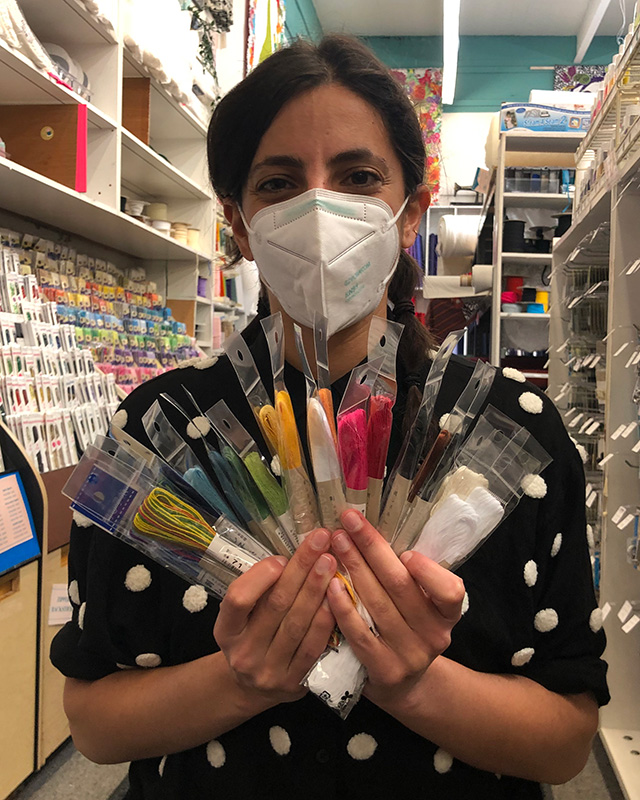 Person holding embroidery thread in fabric store