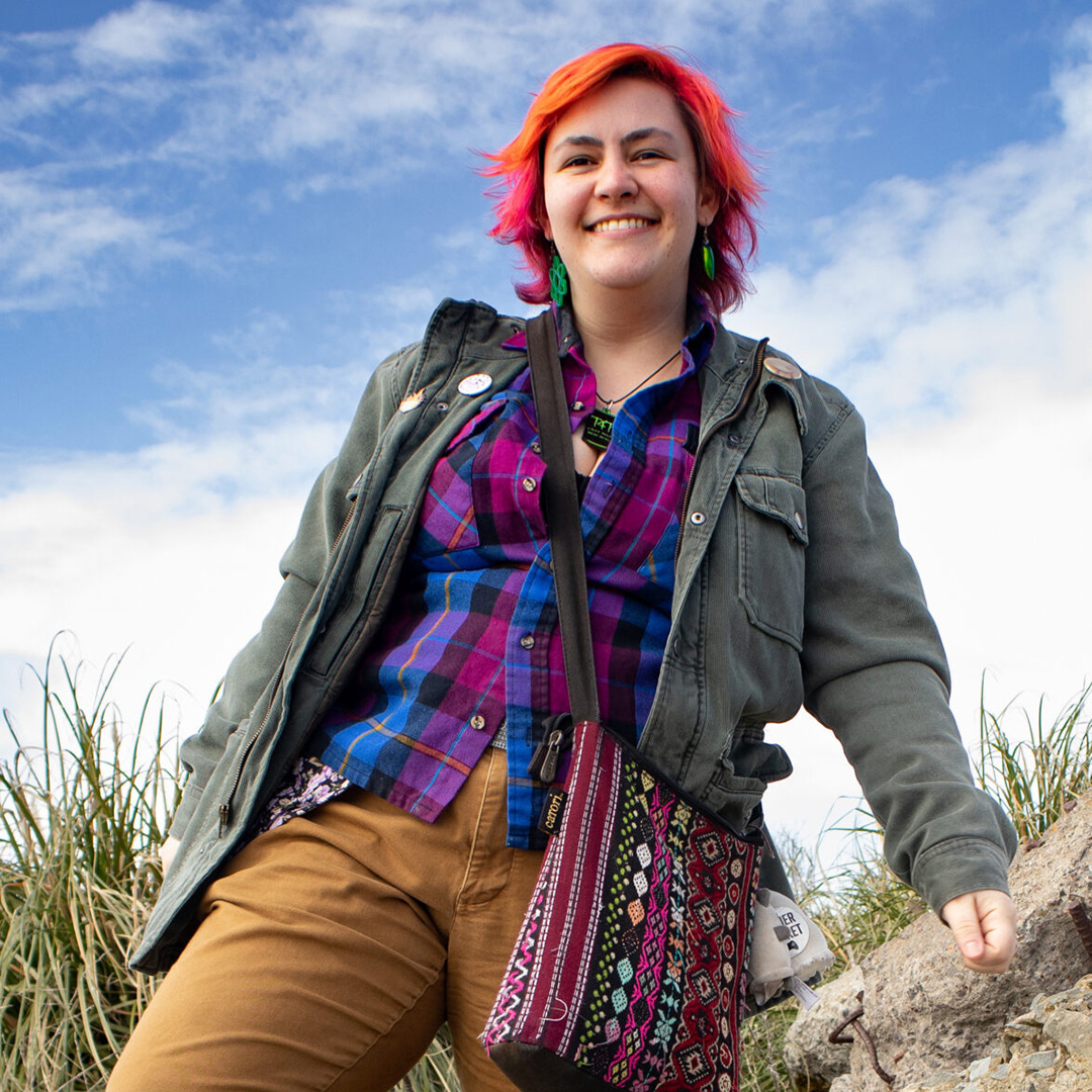 Smiling person with red hair, jacket, outdoors
