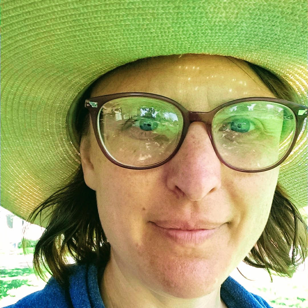 Person in green sunhat with glasses.