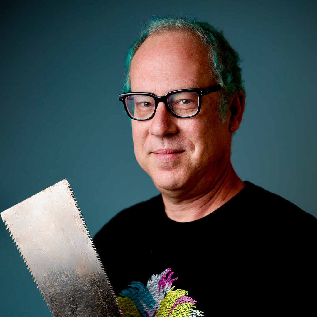 Person with blue hair and glasses, holding Pull Saw.