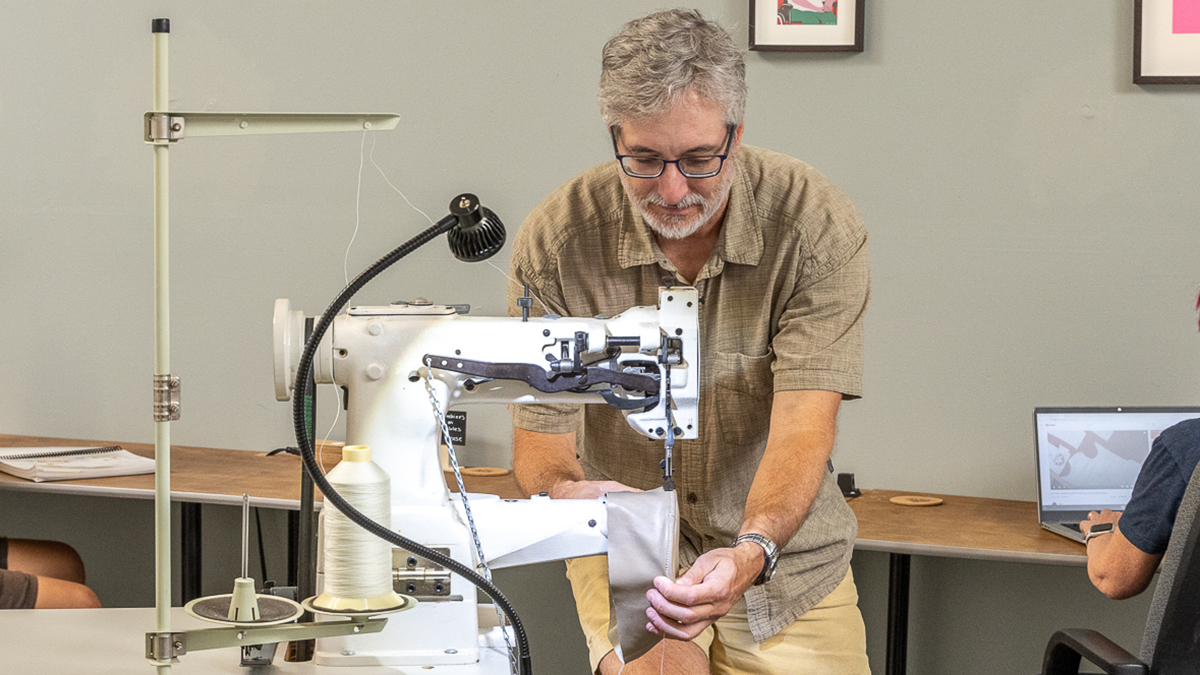 man in front of big sewing machine