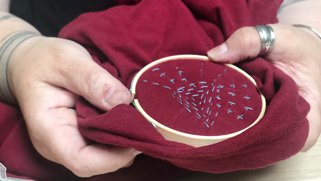 Visible mending, red cloth, blue stitches