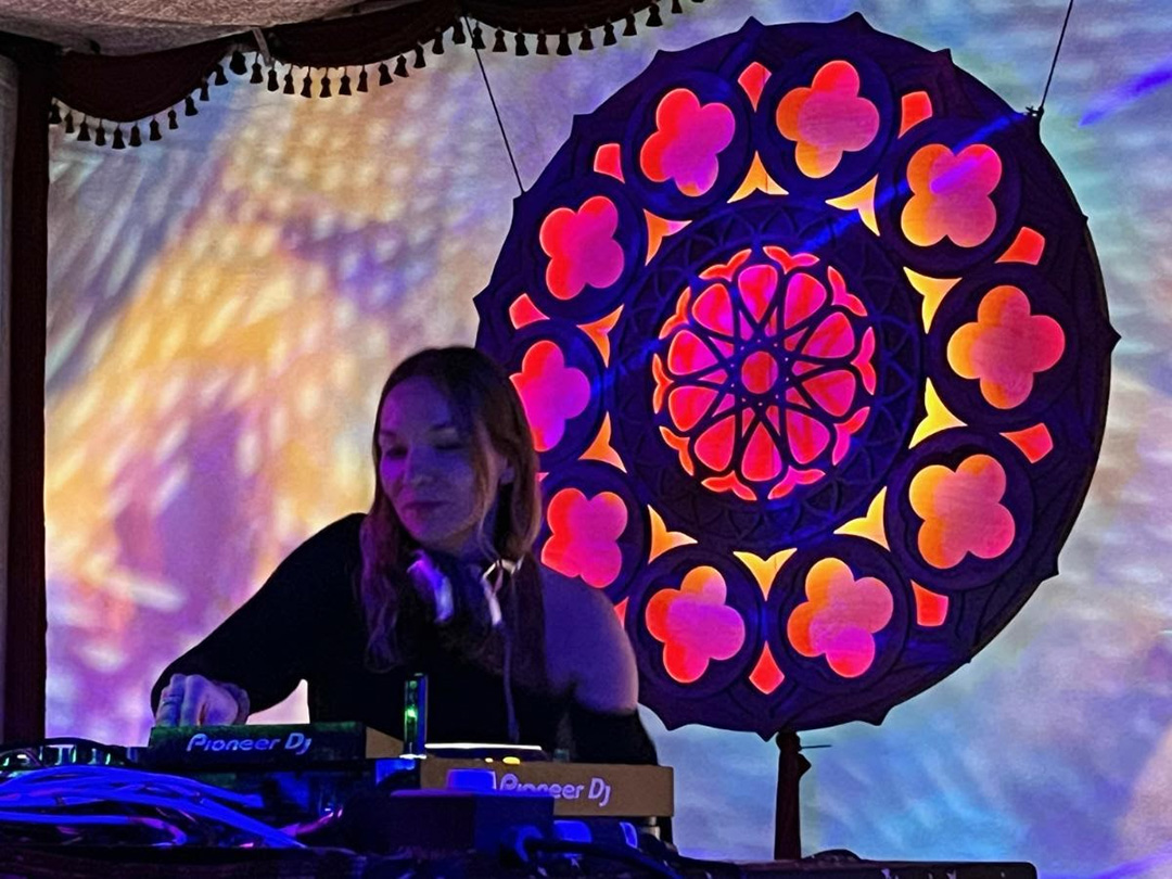 DJ performing in front of the rose window element 