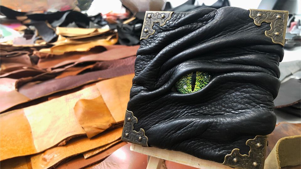 Monster eyeball canvas with green eye, black leather, tan leather scraps.