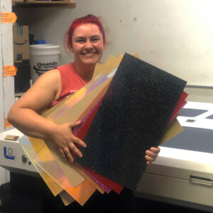 Person holds up a big stack of acrylic sheets.