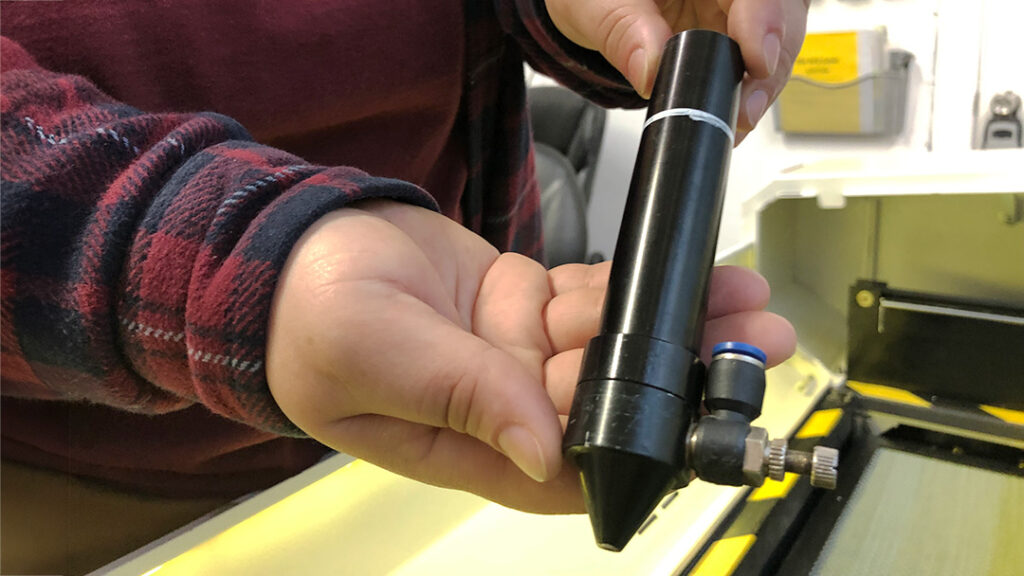 Close-up on persons hands holding laser barrel.