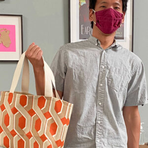Person with orange tote and mask.