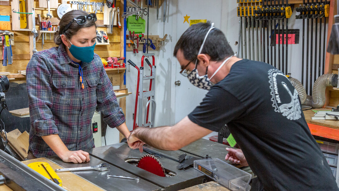 Two people changing blade on Table Saw