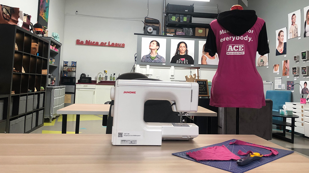 Modified pink shirt with black hood and sleeves, sewing machine.