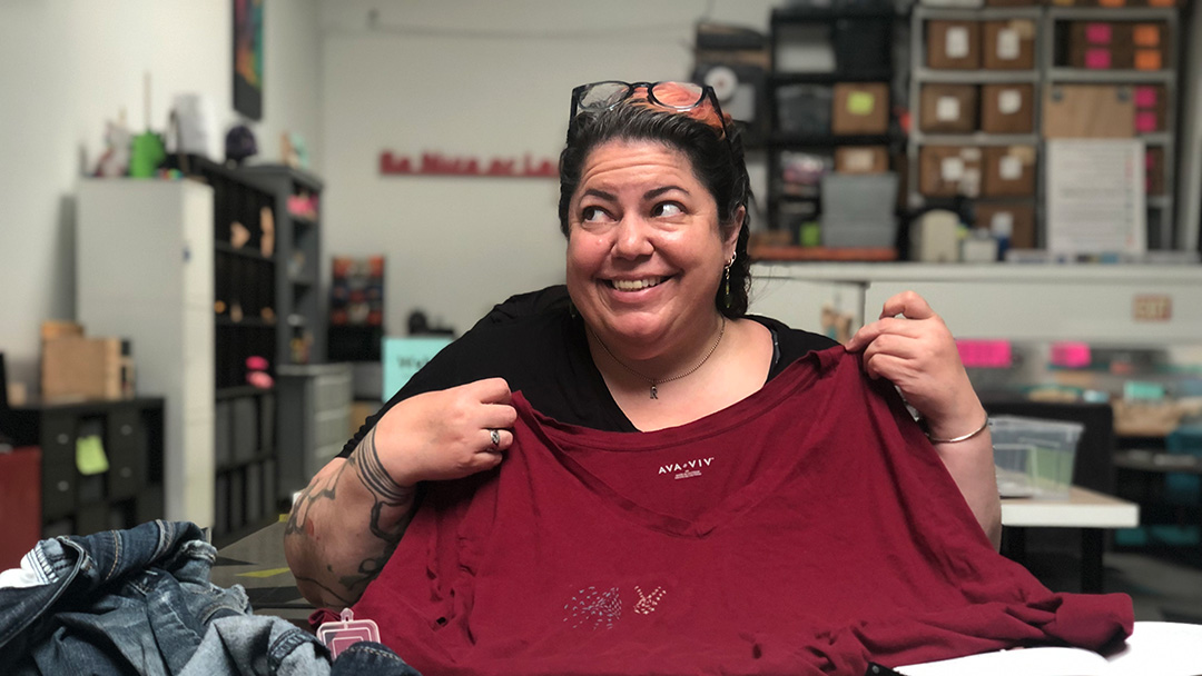 Person smiling with holding red shirt