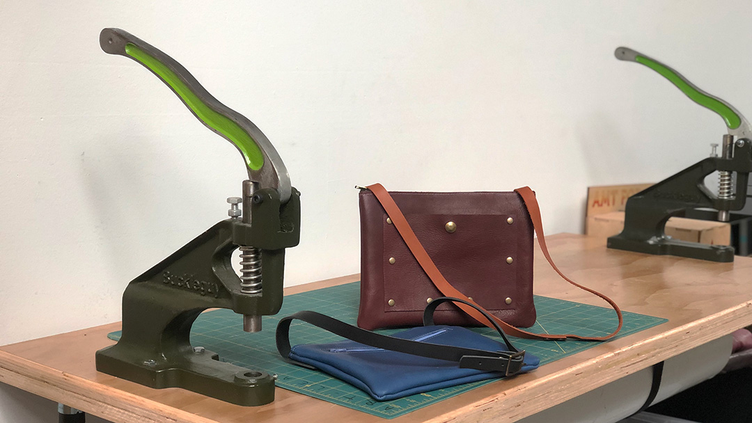 Leather bag, snap setter on table.