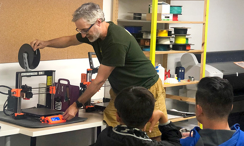 Teacher and students with 3D Printers.